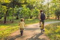 Happy family is riding bikes outdoors and smiling. Father on a bike and son on a balancebike Royalty Free Stock Photo