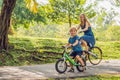 Happy family is riding bikes outdoors and smiling. Mom on a bike and son on a balancebike Royalty Free Stock Photo