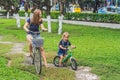 Happy family is riding bikes outdoors and smiling. Mom on a bike Royalty Free Stock Photo