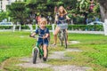 Happy family is riding bikes outdoors and smiling. Mom on a bike Royalty Free Stock Photo