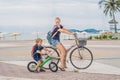 Happy family is riding bikes outdoors and smiling. Mom on a bike and son on a balancebike Royalty Free Stock Photo