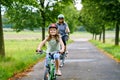 Happy family is riding bikes outdoors and smiling. Mother and daughter, cute little preeschool girl on bicycles, active leisure Royalty Free Stock Photo