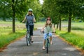 Happy family is riding bikes outdoors and smiling. Mother and daughter, cute little preeschool girl on bicycles, active leisure Royalty Free Stock Photo