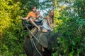 Happy family riding on an elephant, woman sitting on the elephant`s neck