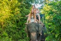 Happy family riding on an elephant, woman sitting on the elephant`s neck Royalty Free Stock Photo