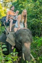Happy family riding on an elephant, woman sitting on the elephant`s neck Royalty Free Stock Photo