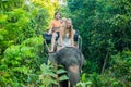 Happy family riding on an elephant, woman sitting on the elephant`s neck Royalty Free Stock Photo