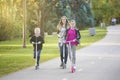 Happy family riding scooters together on a paved pathway outdoors Royalty Free Stock Photo