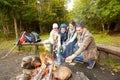 Happy family roasting marshmallow over campfire