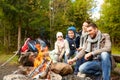 Happy family roasting marshmallow over campfire