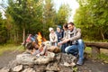 Happy family roasting marshmallow over campfire