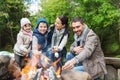 Happy family roasting marshmallow over campfire Royalty Free Stock Photo
