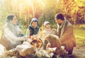 Happy family roasting marshmallow over campfire Royalty Free Stock Photo