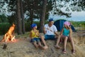 Happy family roasting sausages over campfire. camping and tourism concept Royalty Free Stock Photo