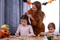 Happy family in a room decorated for Halloween. The boy plays with paints and pencils, the girl draws, and at this time Royalty Free Stock Photo