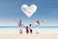 Happy family run at beach under love cloud Royalty Free Stock Photo