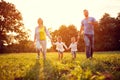 Happy family run on green field Royalty Free Stock Photo