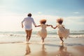 Happy family running on the beach at the day time. Concept of friendly family, rear view Happy young family running and jumping on Royalty Free Stock Photo