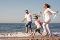 Happy family running on the beach at the day time. Royalty Free Stock Photo