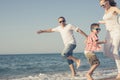 Happy family running on the beach at the day time. Royalty Free Stock Photo