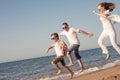 Happy family running on the beach at the day time. Royalty Free Stock Photo