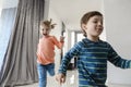 Happy family running in hall. Funny kids jumping  with carton box, parents laughing Royalty Free Stock Photo