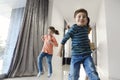 Happy family running in hall. Funny kids jumping  with carton box, parents laughing Royalty Free Stock Photo