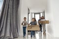 Happy family running in hall. Funny kids jumping  with carton box, parents laughing Royalty Free Stock Photo