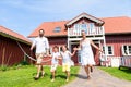 Happy family running on meadow in front of house Royalty Free Stock Photo