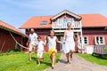 Happy family running on meadow in front of house Royalty Free Stock Photo