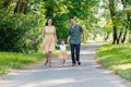 Happy family running on path holding hands and spending time in beautiful green park. Woman pregnant Royalty Free Stock Photo