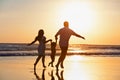 Happy family running by sunset beach Royalty Free Stock Photo