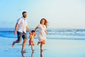 Happy family running by sunset beach Royalty Free Stock Photo