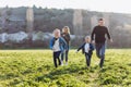 Happy family runs across the field. Father, mother and children run through a green field. Royalty Free Stock Photo