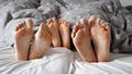 Happy family\'s feet under the blanket. Perfect for representing family time, closeness, and intimacy