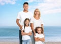 Happy family on sandy beach near sea. Summer vacation