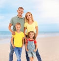 Happy family on sandy beach near sea. Summer vacation