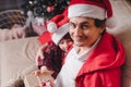 Happy family in Santa hat, father and child son giving Christmas gift at home. Sitting on a couch in the living room Royalty Free Stock Photo