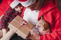 Happy family in Santa hat, father and child son giving Christmas gift at home. Sitting on a couch in the living room with puppy Royalty Free Stock Photo