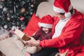 Happy family in Santa hat, father and child son giving Christmas gift at home. Sitting on a couch in the living room Royalty Free Stock Photo