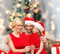 Happy family in santa hats with greeting card Royalty Free Stock Photo