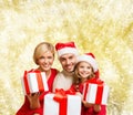 Happy family in santa helper hats with gift boxes Royalty Free Stock Photo