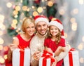 Happy family in santa helper hats with gift boxes Royalty Free Stock Photo