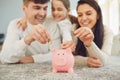 Happy family saves money in a piggy bank pig. Royalty Free Stock Photo