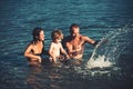 Happy family at a sea having fun and splashing water in summer. Royalty Free Stock Photo