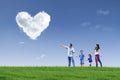 Happy family see heart clouds in the park