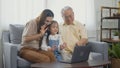 Family senior grandfather, daughter and granddaughter talking online via video chat using laptop computer Royalty Free Stock Photo