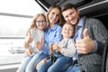 Happy family showing sign ok in auto salon