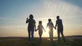 happy family silhouette. group of people family a holding hands walking at sunset by the water on the beach in the park Royalty Free Stock Photo