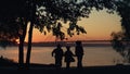 Happy family silhouette run to river hold hands. Beautiful bridge waterway view.